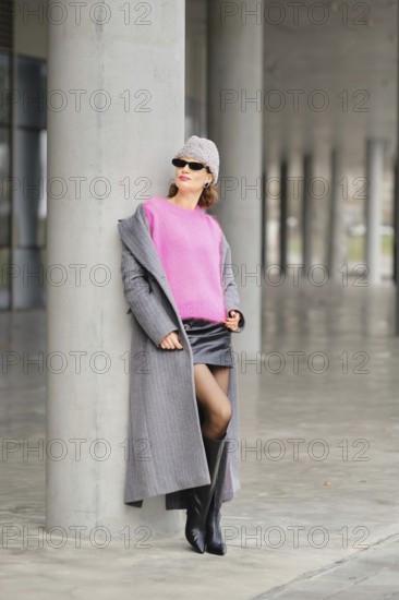 Urban street style with bold colors and modern fashion by a concrete pillar in an urban setting