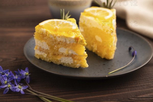 Lemon cake on brown wooden background and linen textile, cup of coffee, side view, close up, selective focus