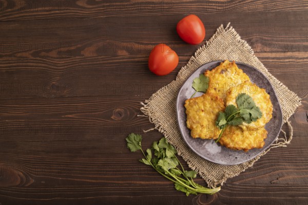 Fried crispy Chicken pancakes on brown wooden background and linen textile. top view, flat lay, copy space