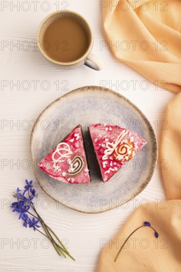 Chocolate cake on white wooden background and orange linen textile, cup of coffee, top view, flat lay, close up