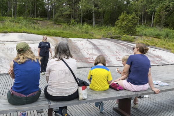 Historic rock carvings in Tanum, here at the Vitlycke site, tourist tour, figurative depiction from the Bronze Age, UNESCO World Heritage Site, Tanum, Västra Götalands län, Sweden