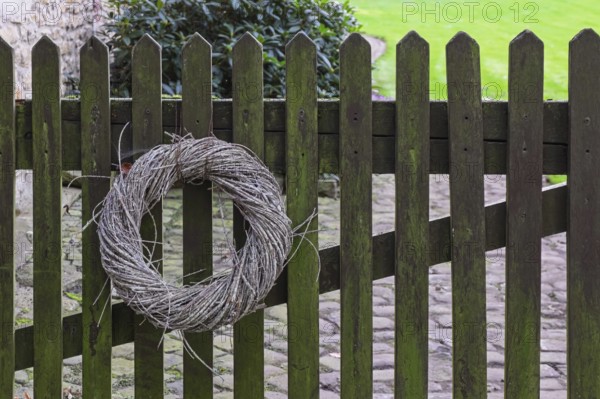 Wreath made of natural materials on an old wooden fence, Münsterland, North Rhine-Westphalia, Germany