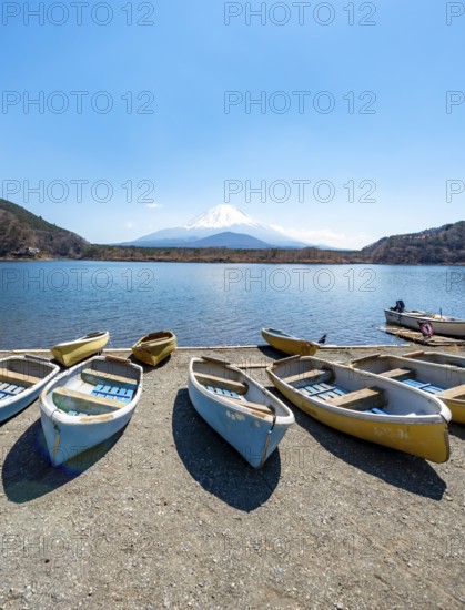 Rowing boats on shore, view across the lake to Mt Fuji volcano, Motosu Lake, Yamanashi Prefecture, Japan