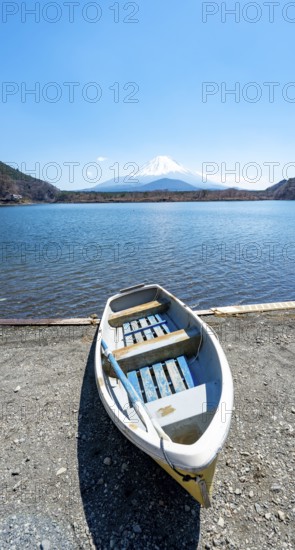Rowing boat on shore, view across the lake to Mt Fuji volcano, Motosu Lake, Yamanashi Prefecture, Japan