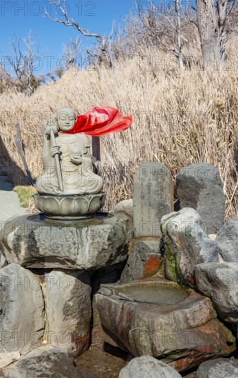 Warm spring water and Buddha statue, Owakudani geothermal area at Komagatake volcano, Hakone, Japan