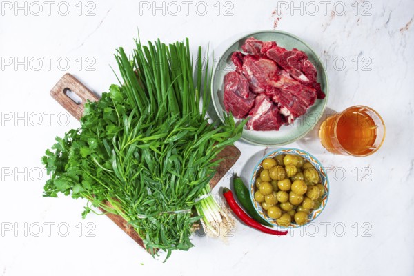 Ingredients for cooking chakapuli, canned tkemali, meat, herbs Georgian cuisine, top view