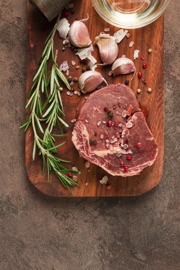 Fresh, raw rib eye steak, on a chopping board, top view, no people