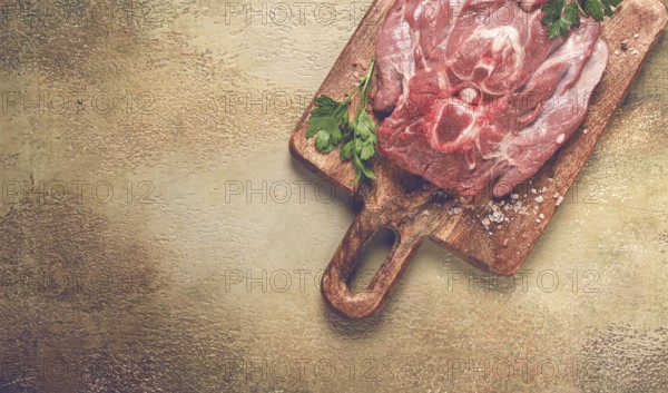 Raw steak, veal neck on the bone, fresh meat, on a cutting board, with spices, top view, without people