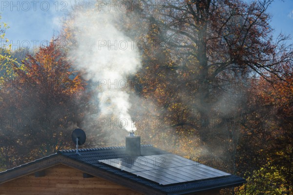 White smoke from fireplace on roof with solar cells, Bischofswiesen, Berchtesgadener Land, Upper Bavaria, Bavaria, Germany