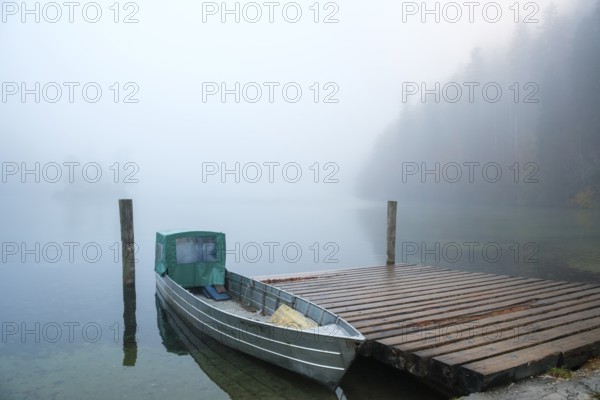 Aluminium boat on a wooden pier at Königssee near fog, Schönau am Königssee, Berchtesgadener Land, Upper Bavaria, Bavaria, Germany