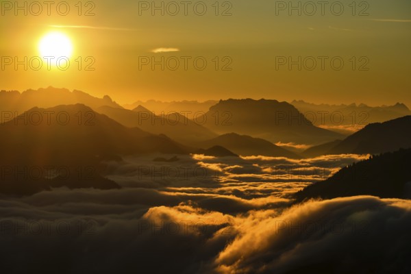 Silhouette of mountains at sunset, fog in valley, Wilder Kaiser and Chiemgau Alps, Upper Bavaria, Bavaria, Germany