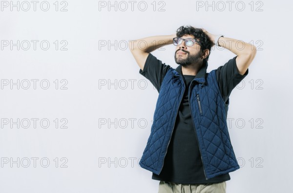 Relaxed young man in glasses with hands behind neck, isolated. Smiling calm guy with hands behind his neck