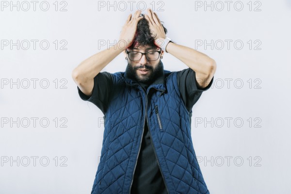 Painful man with a migraine holding his head isolated. Unhappy man with headache concept