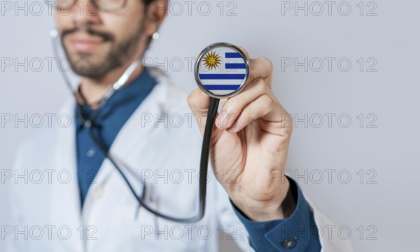 Doctor holding stethoscope with Uruguay flag. Uruguay health and care concept. Uruguay flag on stethoscope