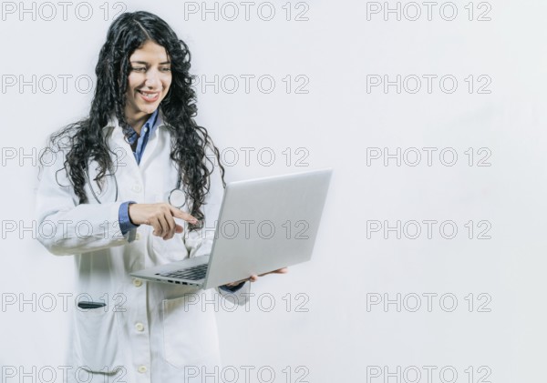 Female young doctor using and pointing laptop isolated. Smiling Woman doctor using laptop on isolated background