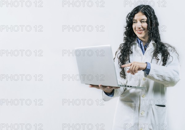 Smiling Woman doctor using laptop on isolated background. Female young doctor using and pointing laptop isolated