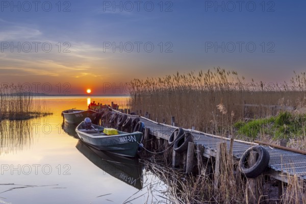 Fishing boats at wooden jetty on Lieper Winkel peninsula near Rankwitz on Usedom island in the Baltic Sea at sunset, Mecklenburg-Vorpommern, Germany