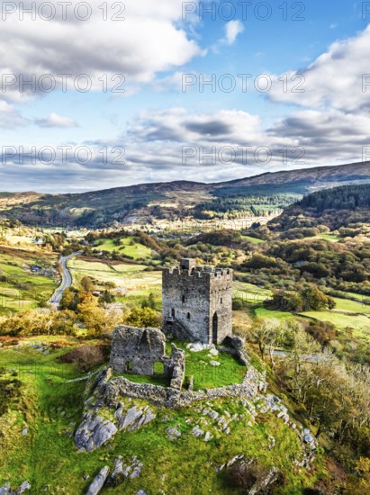 Autumn colours over Castell Dolwyddelan and Eryri Mountains from a drone, Snowdonia, Conwy County Borough, Wales, England, United Kingdom