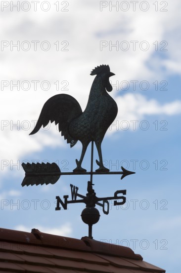 Metallic silhouette of a weather cock against blue sky with clouds, Baden-Württemberg, Germany