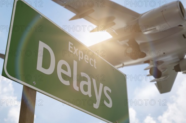 Expect delays green road sign with airplane above