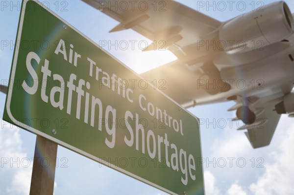 Air traffic control staffing shortage green road sign with airplane above
