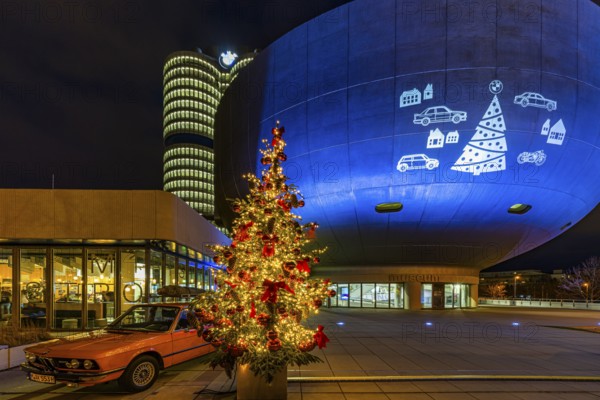 Illuminated Christmas tree with red balls, next to a historic BMW vehicle, in front of the BMW Museum, BMW World, Petuelring, Munich, Upper Bavaria, Bavaria, Germany