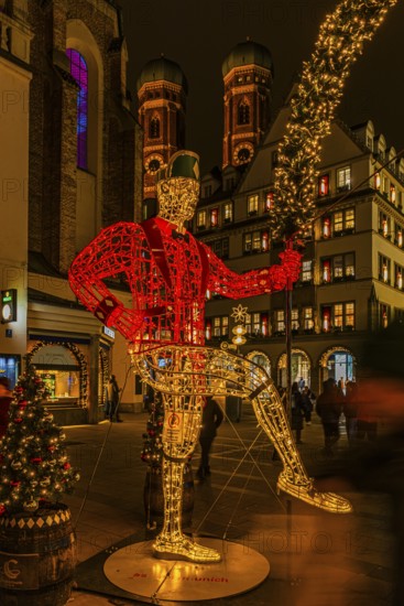 Schäffler dancers made of wire and string of lights, in the back the towers of the Church of Our Lady, Cathedral of Our Lady, Christkindlmarkt, Neuhauserstraße, Munich, Upper Bavaria, Germany