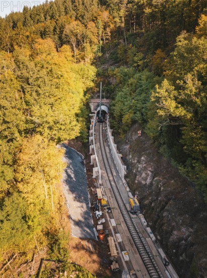 Autumn view of construction site from the air with tunnel boring machine and construction vehicles in the forest, Bau der Hermann, Hesse, Bahn, Calw, Germany