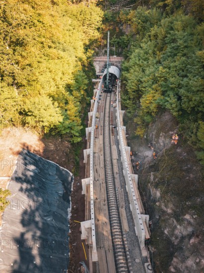 Aerial view of a rail construction site in the forest with tunnel boring machine and workers, construction of Hermann, Hesse, Bahn, Calw, Germany