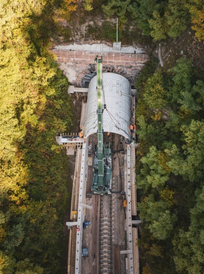 Drone photo of a crane working on a tunnel structure in an autumn environment, built by Hermann, Hesse, Bahn, Calw, Germany