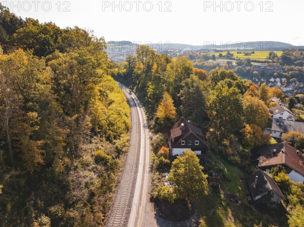 Village in autumn landscape next to railroad tracks and view of hills, building of Hermann, Hesse, railway, Calw, Germany