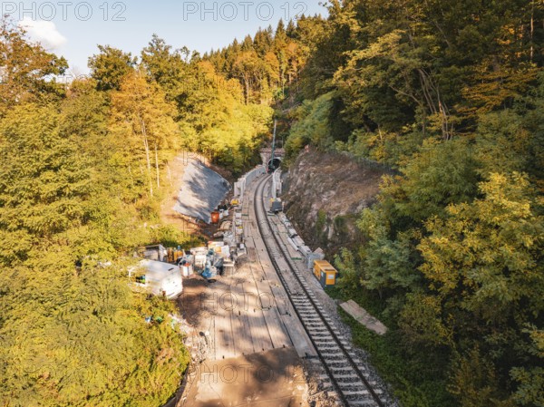 Construction work on railway tracks in an autumnal forest in sunny weather with machines, construction of Hermann, Hesse, Bahn, Calw, Germany