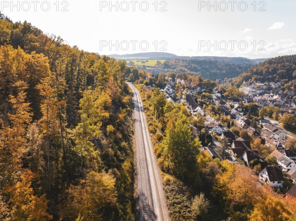 Aerial view of railroad tracks through an autumnal landscape next to a village, Bau der Hermann, Hesse, Bahn, Calw, Germany