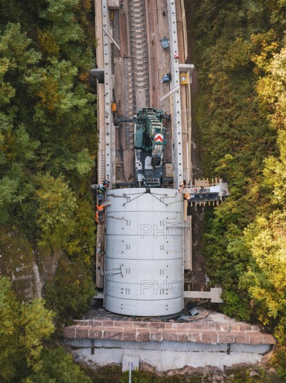 Machine building tracks in an autumnal forest area placed on a railroad track, construction of Hermann, Hesse, Bahn, Calw, Germany