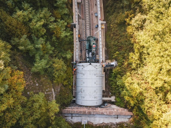 Bird's eye view shows crane over tunnel on a railway line surrounded by trees, construction of Hermann, Hesse, Bahn, Calw, Germany
