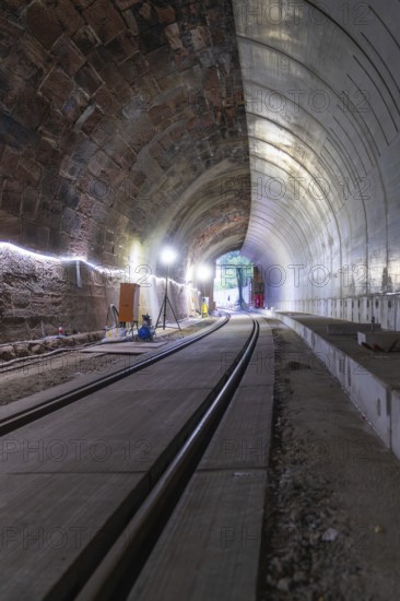 Tunnel with rails and illuminated exit, various materials visible, construction of Hermann, Hesse, railway, Calw, Germany