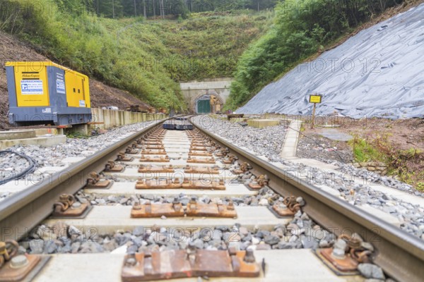 Rails lead to a tunnel surrounded by gravel and construction machinery, built by Hermann, Hesse, Bahn, Calw, Germany