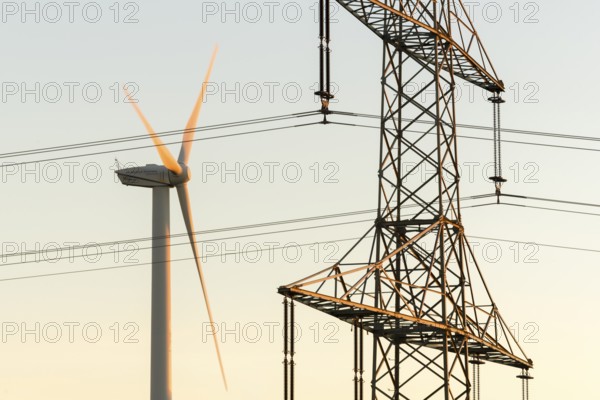 Wind turbine next to a power pole with wires, technical motif, Swabian Jura, Baden-Württemberg, Germany
