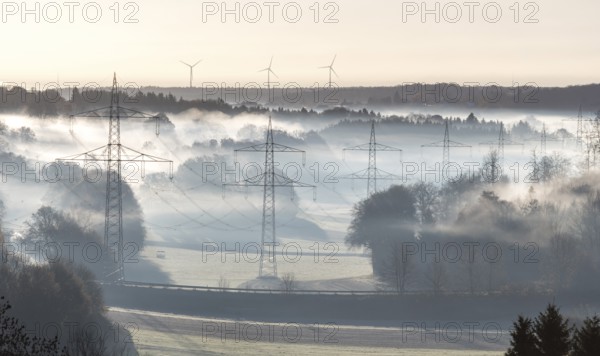 Foggy landscape with power poles and distant wind turbines in the morning, Swabian Jura, Baden-Württemberg, Germany