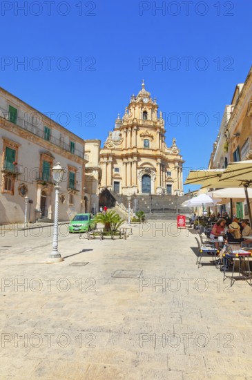 Tourists sitting in local restaurants in the main square, Ragusa Ibla, Ragusa province, Sicily, Italy