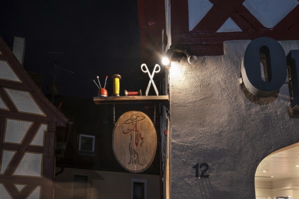 Nocturnal view of a tailor shop's nose shield, Lauf an der Pegnitz, Middle Franconia, Bavaria, Germany