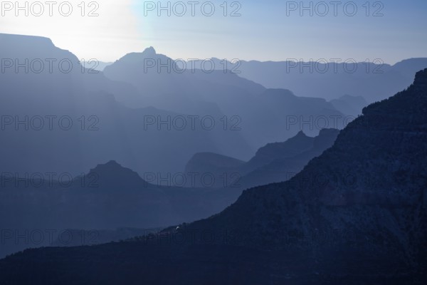 Scenic layers of the grand canyon in the early morning with hikers cabin roof shining in the lower middle