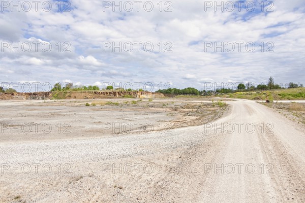 Landscape view with a gravel road in a limestone quarry on a sunny summer day