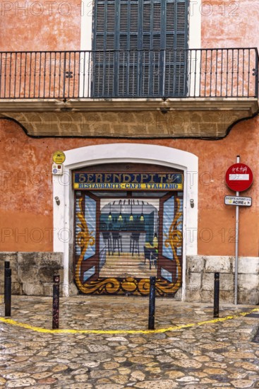 Restaurant with roll-down shutter blinds with graffiti painting on a street corner in the city, Palma de Mallorca, Mallorca, Spain