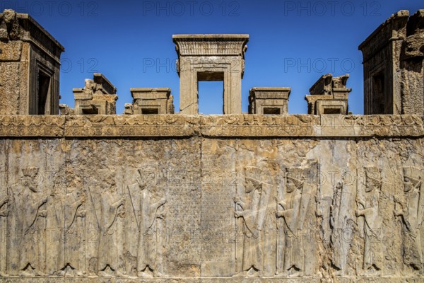 Persian wax soldiers on the western steps of the Darius Palace with cuneiform script, Persepolis