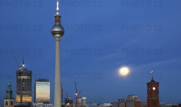 The moon shines on Alexanderplatz, St. Mary's Church, The Berlinian skyscraper construction site, Hotel Park Inn, television tower, red town hall, Berlin, 05.11.2025, Berlin, Germany