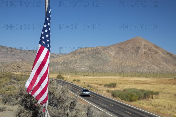 Austin, Nevada - A flag flies in the Nevada desert above state highway 305. The flag is on the site of a former Nevada Central Railroad. station