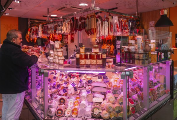Market stall shop store selling cheese and delicatessen meat products inside Mercado Central de Zaragoza, Zaragoza, Aragon, Spain