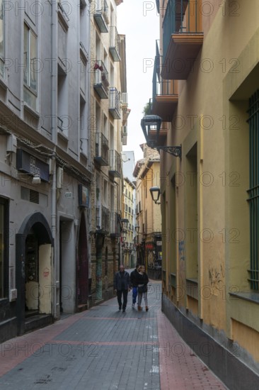 People walking along narrow alleyway street in the Old Town area, city ofZaragoza, Aragon, Spain