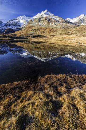 Mountains reflected in lake, morning light, autumn, sunny, Bernina Pass, Engadin, Switzerland